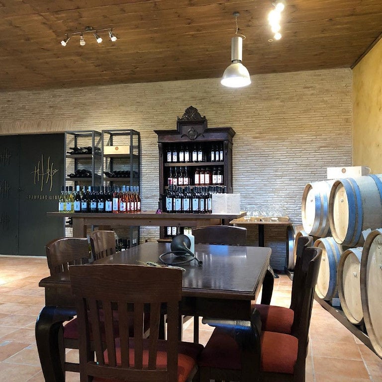 Klima Grampsa wine tasting room with wood barrels on top of each other on the wall